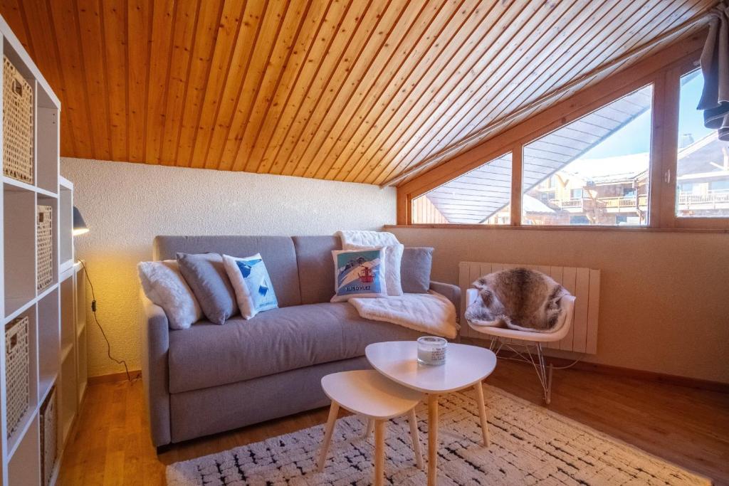 a living room with a couch and a table at Cosy duplex with view in Huez - Welkeys in LʼHuez