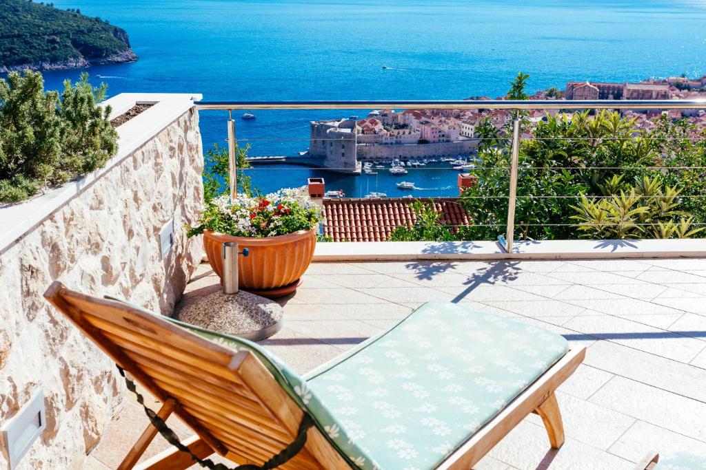 une chaise sur un balcon avec vue sur l'océan dans l'établissement Luxury Apartments Con Vista, à Dubrovnik