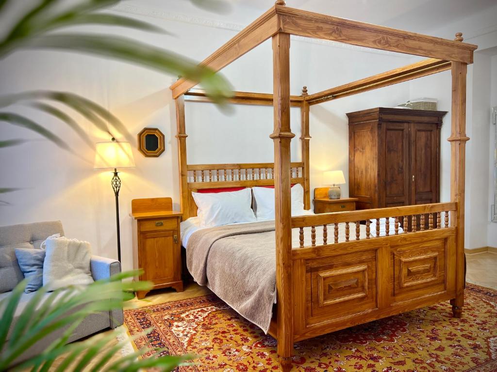 sypialnia z drewnianym łóżkiem z baldachimem i kanapą w obiekcie Zentrum Vintage Appartments w Braszowie