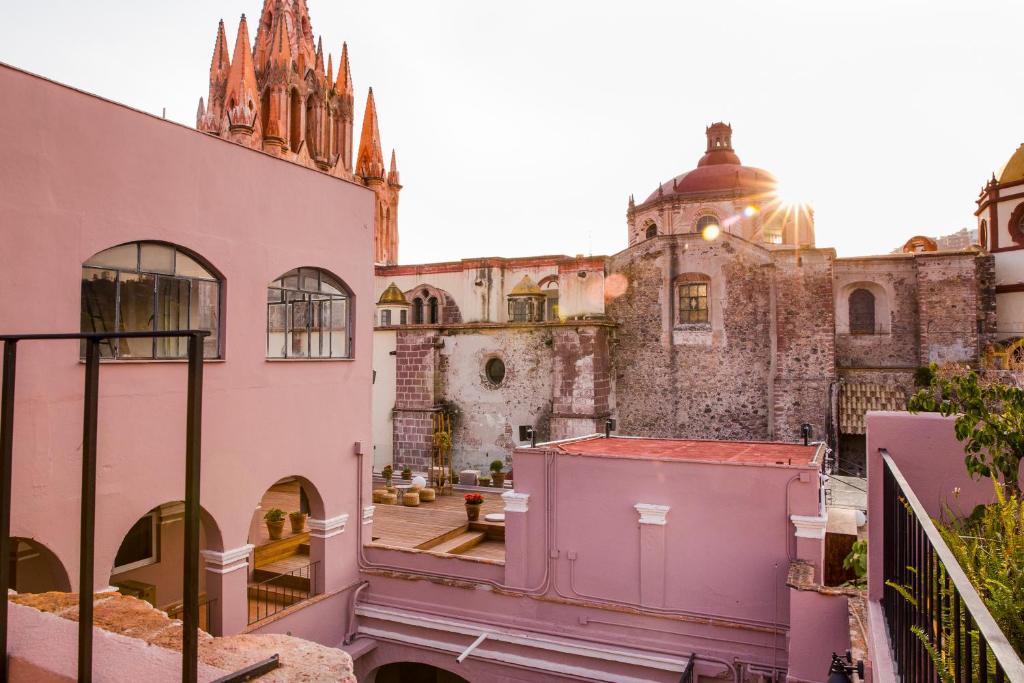 uma vista a partir da varanda de um edifício antigo com uma igreja em Selina San Miguel de Allende em San Miguel de Allende