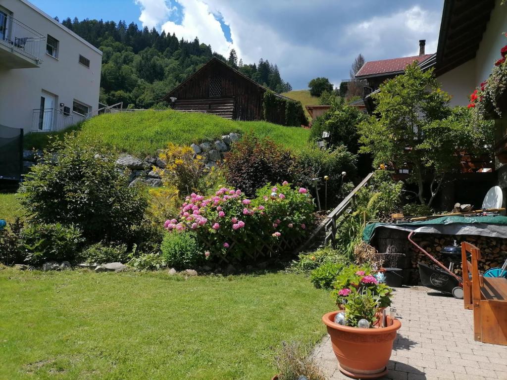 a garden with flowers and plants in a yard at Landhaus Berthold in Bürserberg