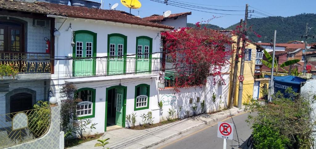 an old building with green doors on a street at Pousada Sonho Meu in Paraty