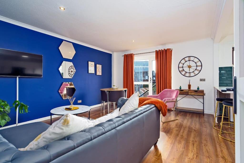 sala de estar con sofá y pared azul en New Slick Finnieston Pad w/ Free Parking en Glasgow