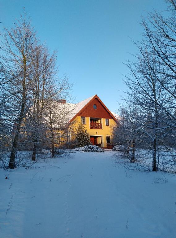 a house in a field with snow on the ground at Gospodarstwo Agroturystyczne w Łoskoniu Starym 