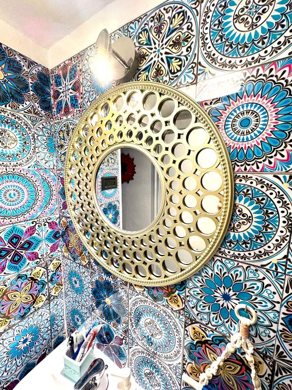 a mirror on a bathroom wall with colorful tiles at Relax House in Bari