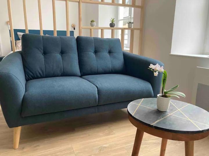 un canapé bleu dans un salon avec une table dans l'établissement Au coeur de la Vieille Ville - Vue Cathédrale, à Boulogne-sur-Mer