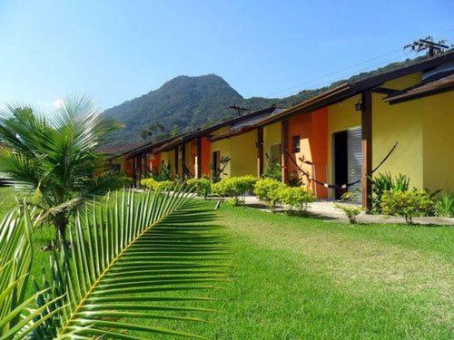 um edifício com uma palmeira em frente em Pousada Ana e o Mar em Ubatuba