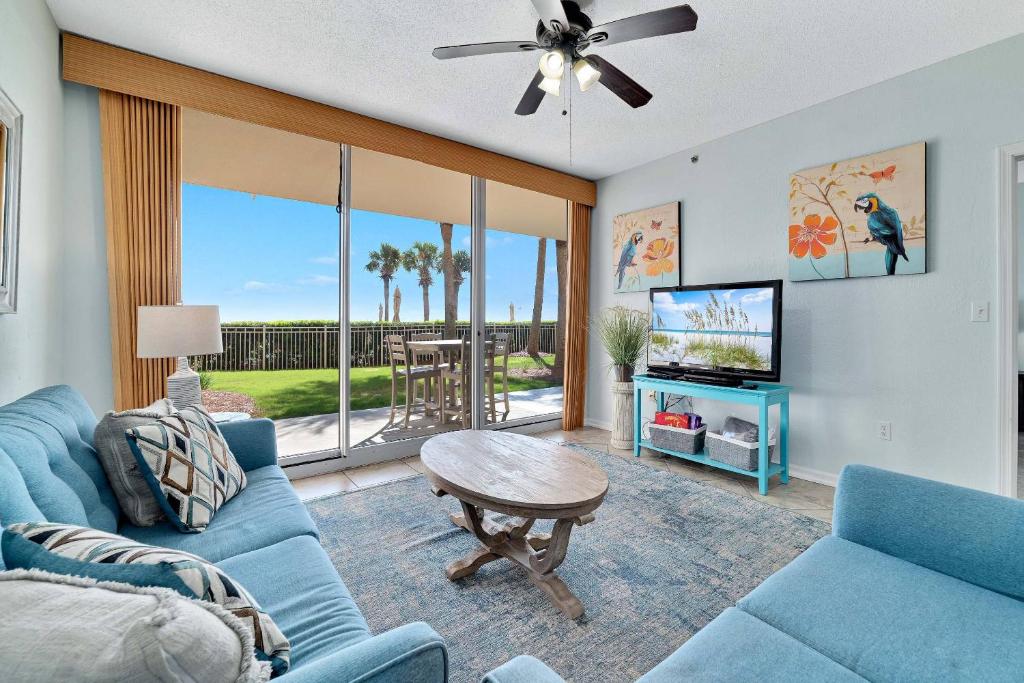 a living room with a blue couch and a tv at Beach Club C-103 in Gulf Shores