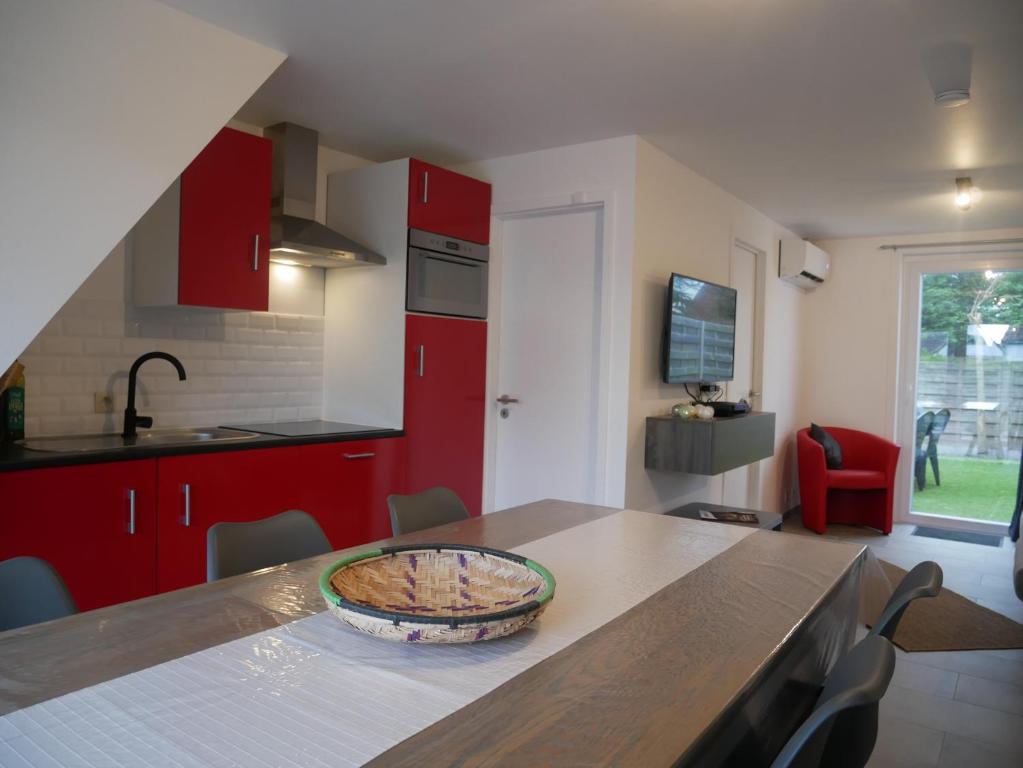 eine Küche mit roten Schränken und einem Tisch mit Kuchen drauf in der Unterkunft Seastar in Bredene