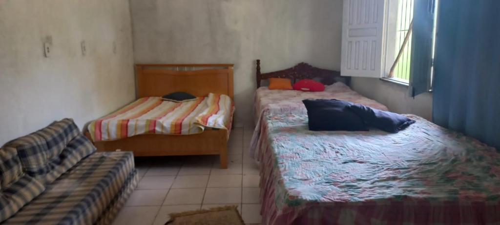 um quarto com duas camas e um sofá em Chácara Fênix em São Cristóvão