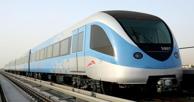 a blue and white train on the tracks at Welcome Hostel in Dubai