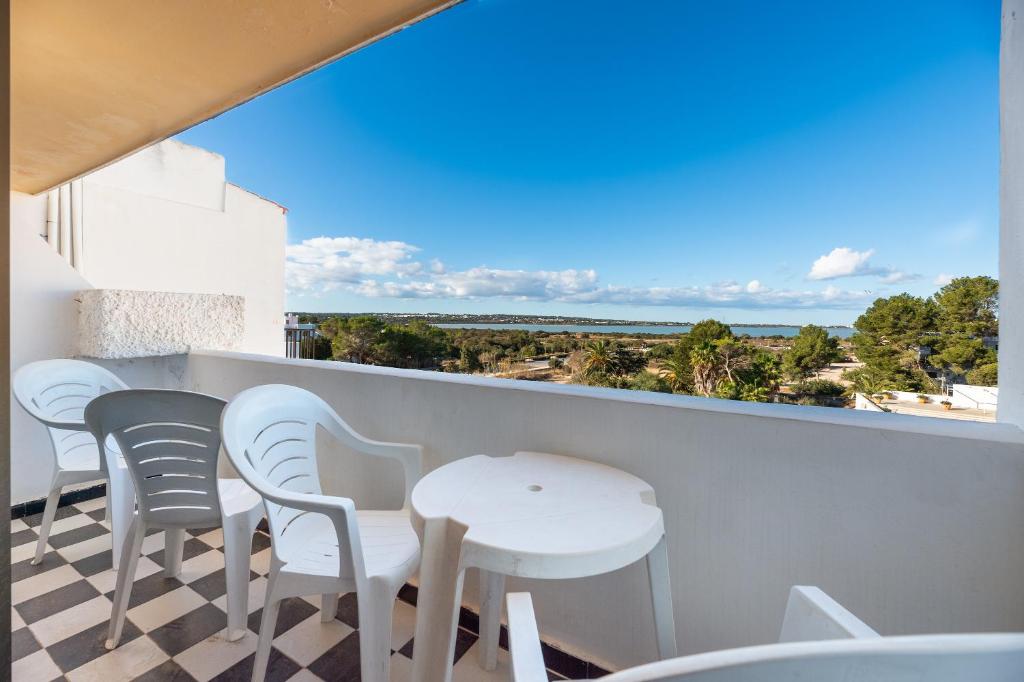 een balkon met een tafel en stoelen en uitzicht op de oceaan bij Apartamento Bilo 302 in Es Pujols