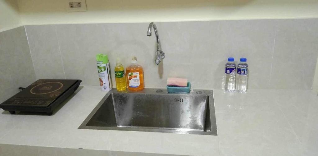 a kitchen counter with a sink and bottles of soap at 2 Bedroom Guest Suite Near The New EVRMC Hospital & San Juanico Bridge Tacloban City, Leyte, Philippines in Tacloban