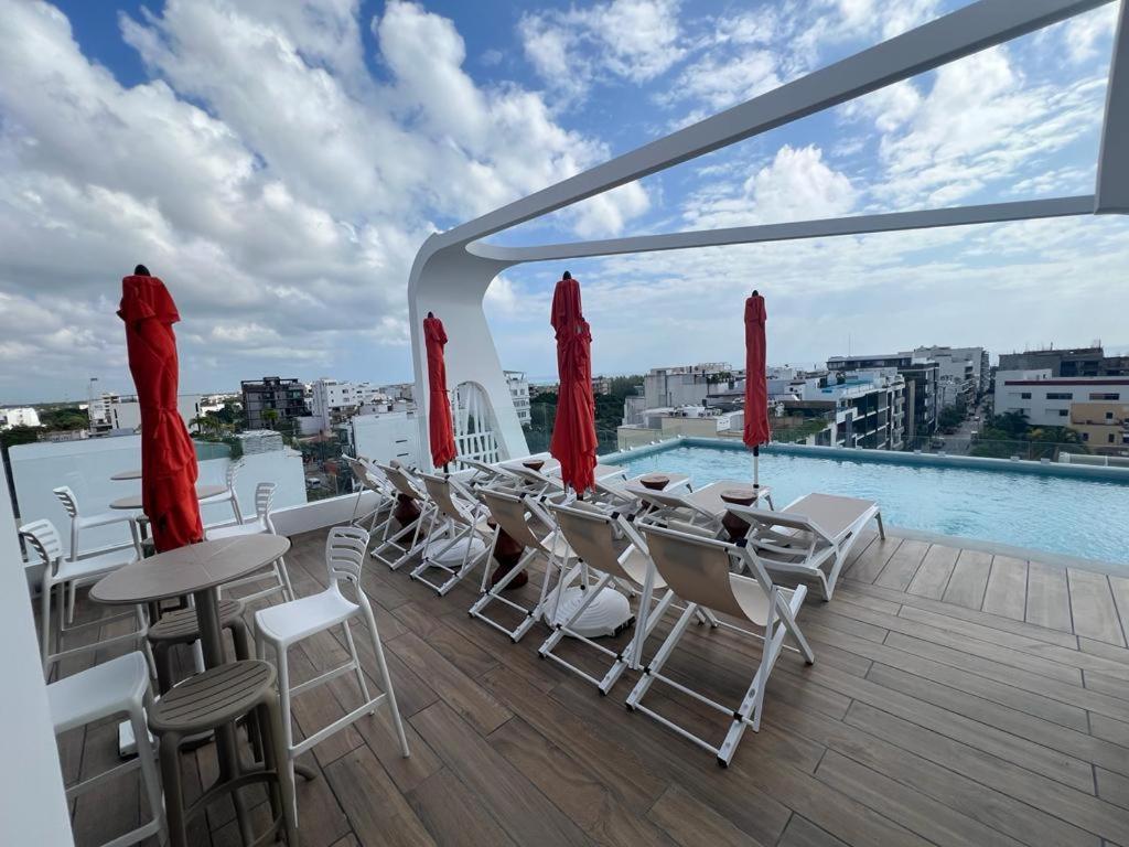 un balcone con sedie, tavoli e piscina di Alizee Tower a Playa del Carmen