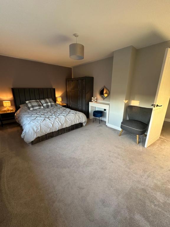 a bedroom with a bed and a desk and a chair at Elwood - spacious contemporary home from home in Harrogate with parking in Harrogate
