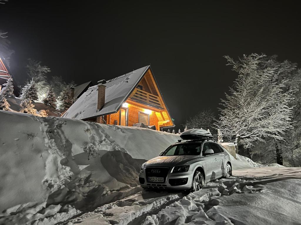 a car parked in the snow in front of a house at Kuća za odmor ALTEA Pridolci in Busovača