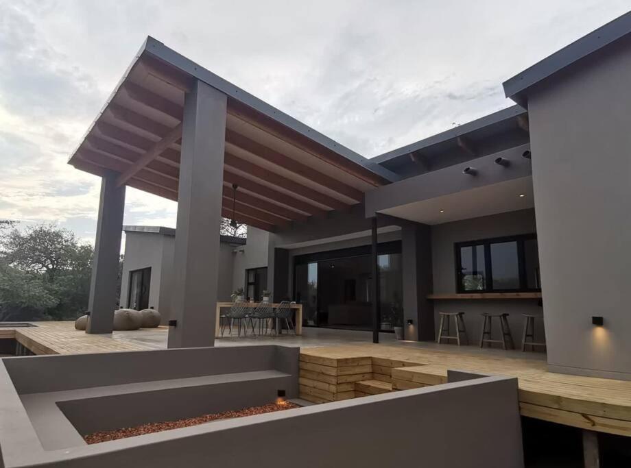 a modern house with a patio with a fire pit at Corkwood Villa in Hoedspruit