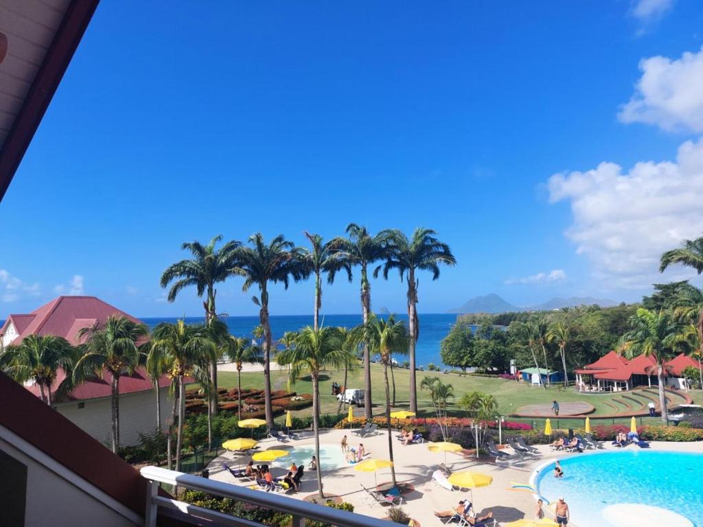 a view from the balcony of a resort with a pool and palm trees at Village Sainte Luce, Martinique - maeva Home - Appartement 3 pièces 6 personnes - Prestige MAE-8354 in Sainte-Luce