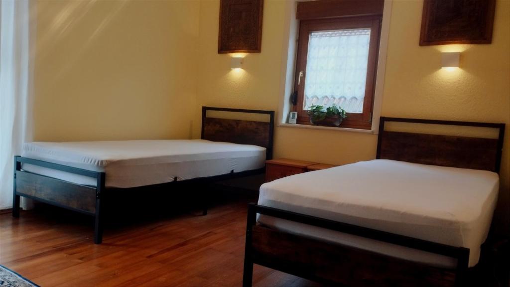 2 Betten in einem Zimmer mit Fenster in der Unterkunft Zimmer mit zwei Einzelbetten in Schömberg