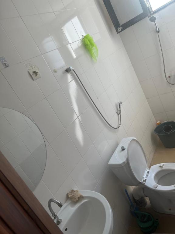 a small bathroom with a toilet and a shower at Douks in Dakar