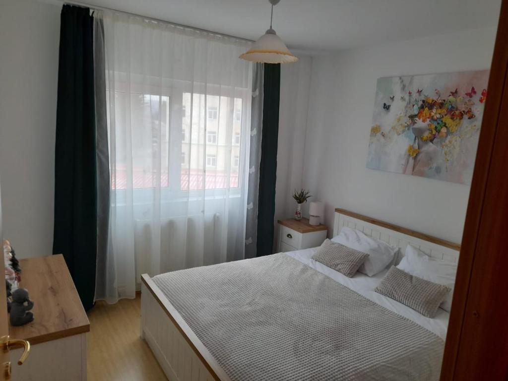 una camera con un letto bianco e una finestra di Orsy House a Făgăraş