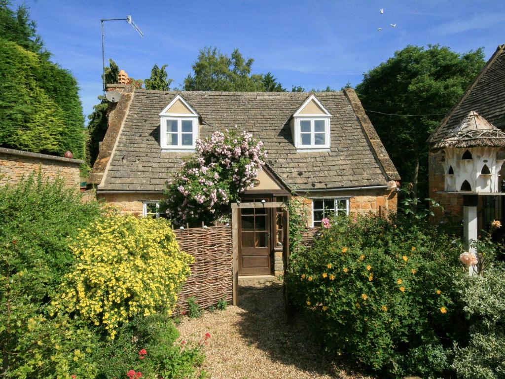 a small house with flowers in the front yard at Hadcroft Cottage in Chipping Campden