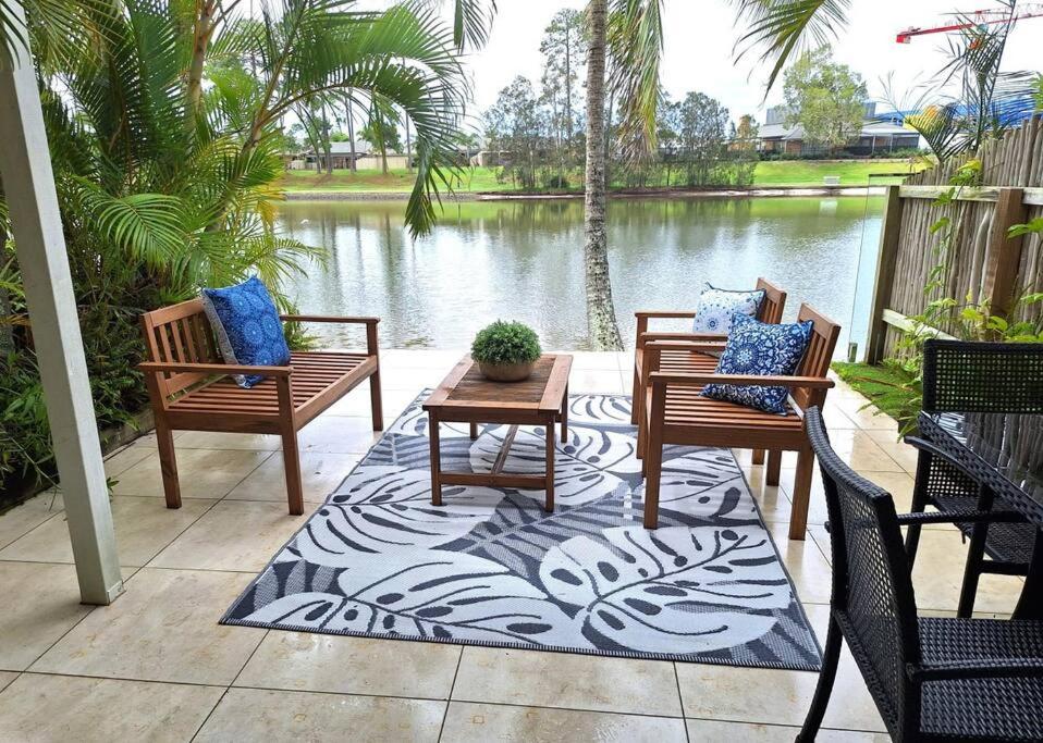 a patio with three chairs and a table and a pond at Isle of Palms 31 in Gold Coast