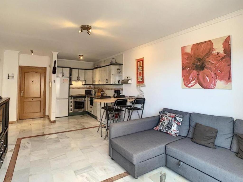a living room with a couch and a kitchen at Apartamento Manilva con terraza y piscina in Manilva