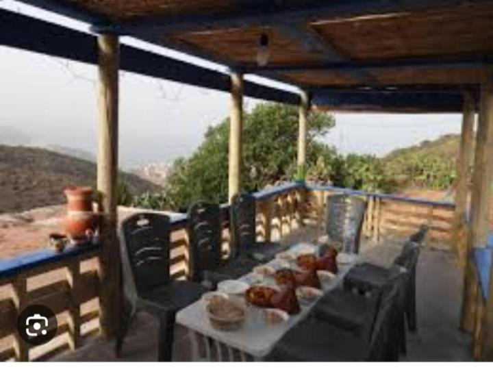 una mesa y sillas en un balcón con vistas en Casa de campo, en Alhucemas