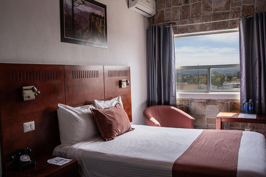 Habitación de hotel con cama y ventana en Hotel Casablanca en Durango