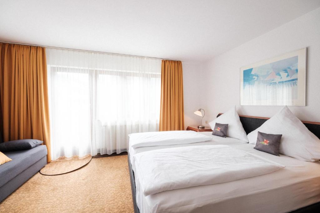 Postel nebo postele na pokoji v ubytování Hotel Flora Möhringen