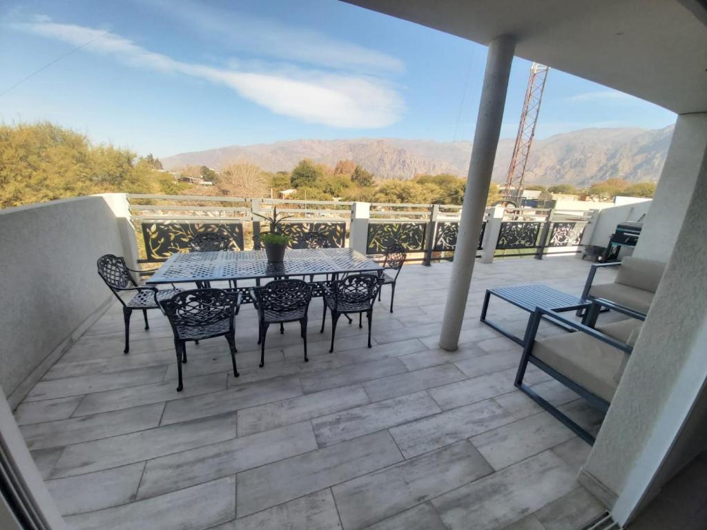 patio con mesa y sillas en el balcón en Departamento en los Valles en Cafayate