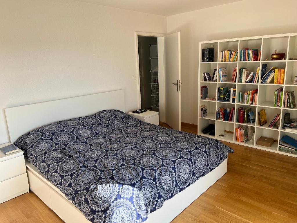 um quarto com uma cama e estantes de livros com livros em 3 Zimmer Wochnungsvermitung in Orpund -Biel em Orpund