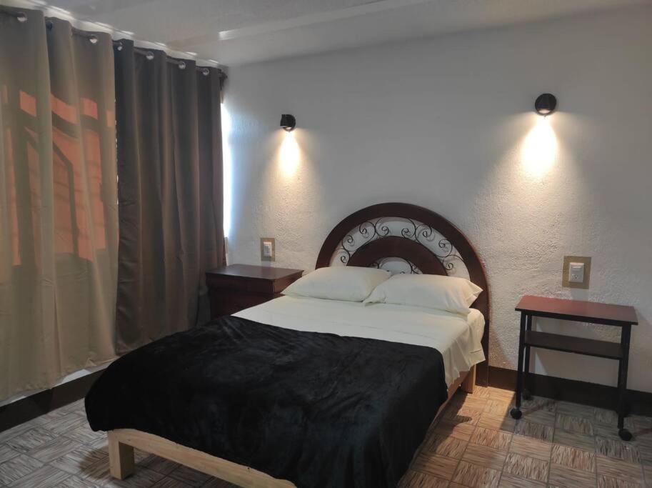 1 dormitorio con 1 cama grande y 2 mesitas de noche en Hospedaje Guadalajara, en Guadalajara
