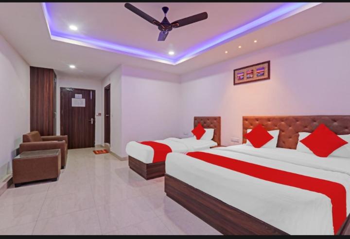 een hotelkamer met 2 bedden en een plafondventilator bij Hotel SS PALACE in Lucknow