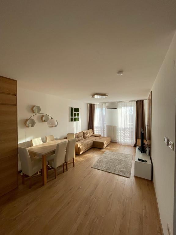 een woonkamer met een tafel en een bank bij Sarló Apartman in Debrecen