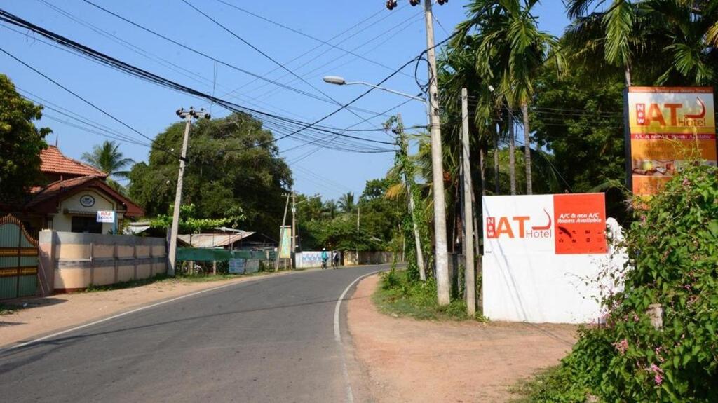 una strada vuota con un cartello "Mangia" sul lato della strada di New AT hotel a Jaffna