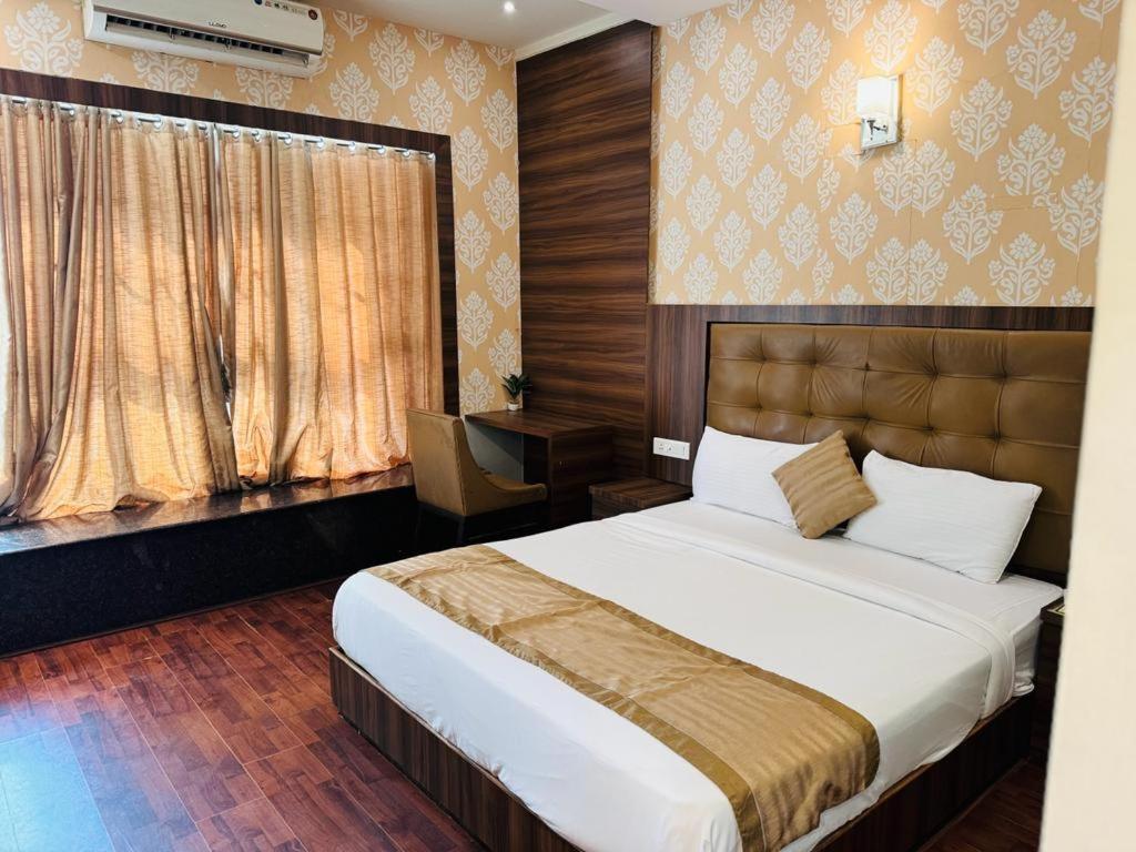 a bedroom with a large bed and a window at Hotel BKC Mannat in Mumbai