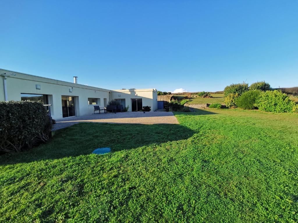 une maison avec une grande pelouse devant elle dans l'établissement BRETAGNE - La Villa Littorine, à Ploemeur