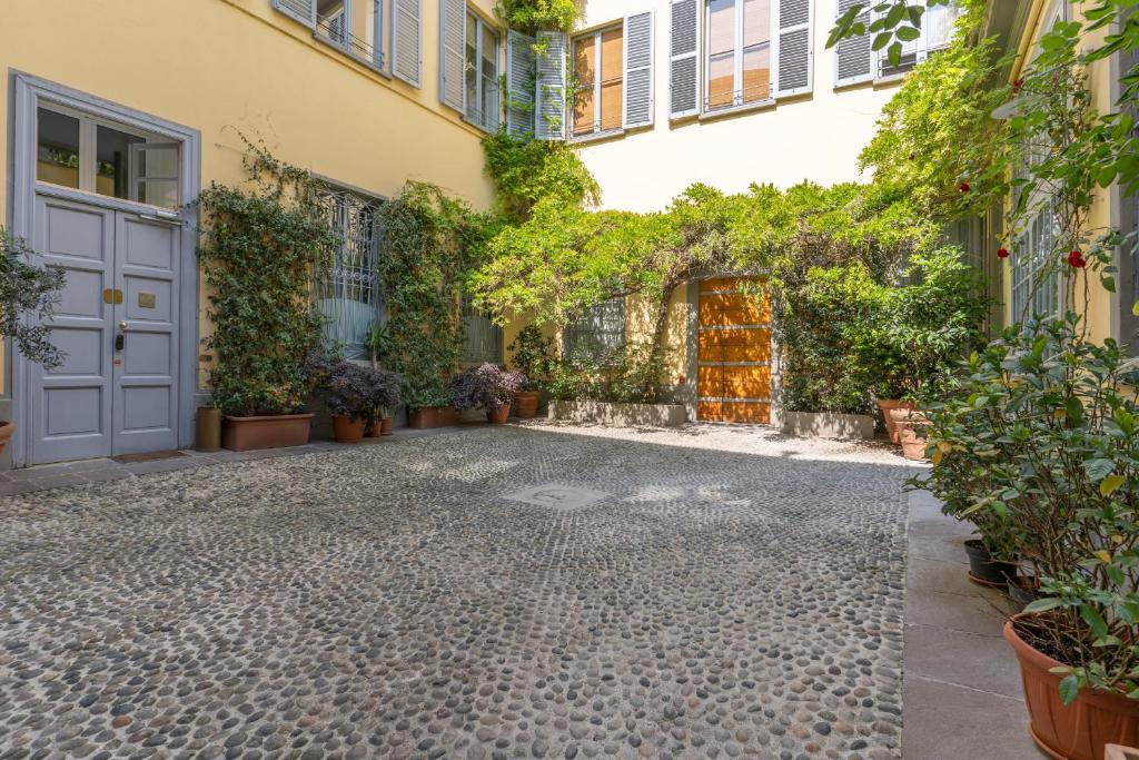 a courtyard of a building with a door and plants at Duomo Smart Suites in Milan