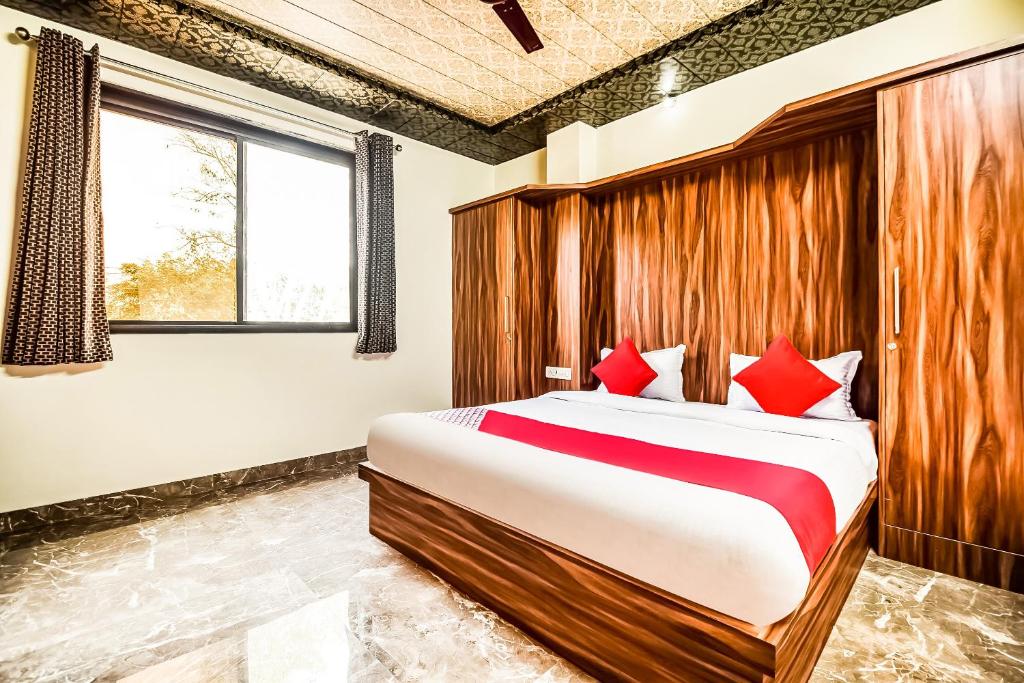 a bedroom with a large bed with red pillows at Eleven Suites in Kota
