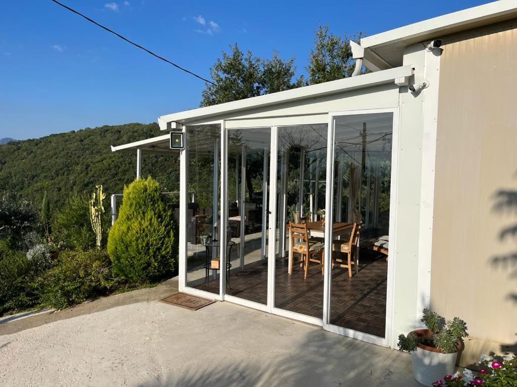 einen Wintergarten mit Glasschiebetüren und einem Tisch in der Unterkunft Lory's Home in Caiazzo