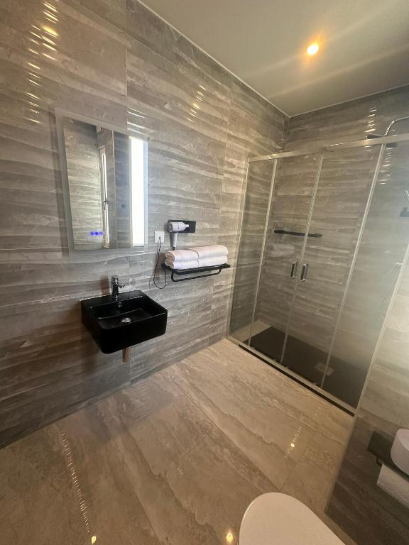 a bathroom with a sink and a shower at La Bella Guesthouse in St. Julianʼs