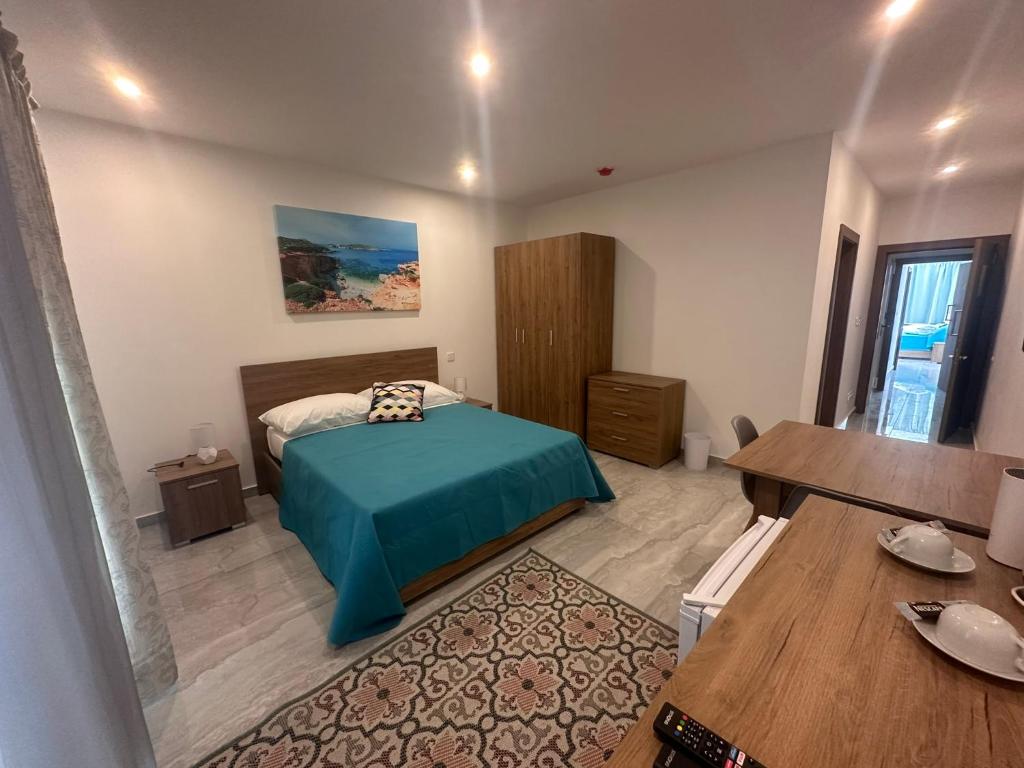 ein Schlafzimmer mit einem Bett und einem Tisch in einem Zimmer in der Unterkunft La Bella Guesthouse in St Julian's