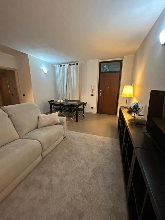 uma sala de estar com um sofá branco e uma mesa em modern apartment Legnano em Legnano