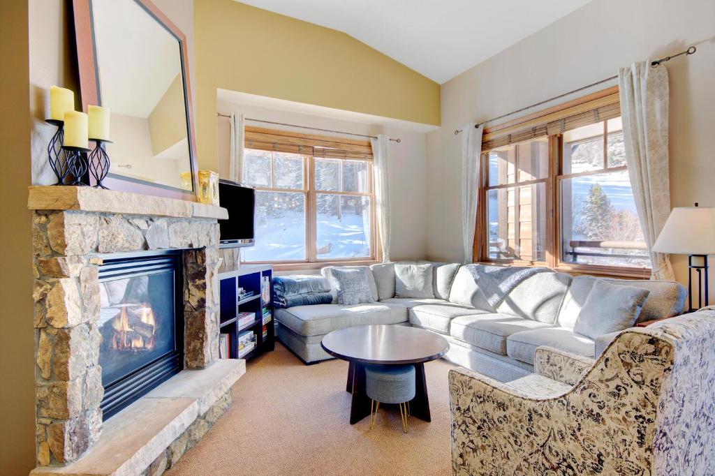 een woonkamer met een bank en een open haard bij Ski In Out Luxury Penthouse #1703 With Hot Tub & Great Views - 500 Dollars Of FREE Activities & Equipment Rentals Daily in Winter Park