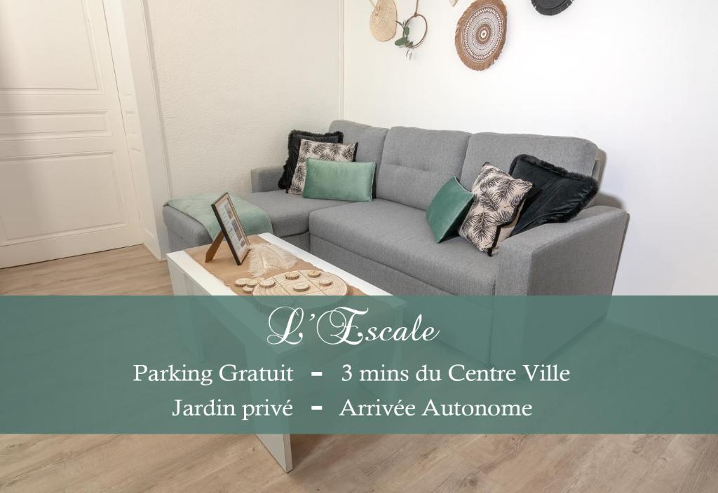 een woonkamer met een grijze bank en een salontafel bij Appartement - L'ESCALE DE MONTMOROT - CALME & SÉRÉNITÉ in Montmorot