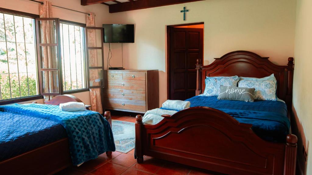 1 dormitorio con 1 cama y 1 cruz en la pared en Palacio del conquistador, en San Cristóbal El Bajo