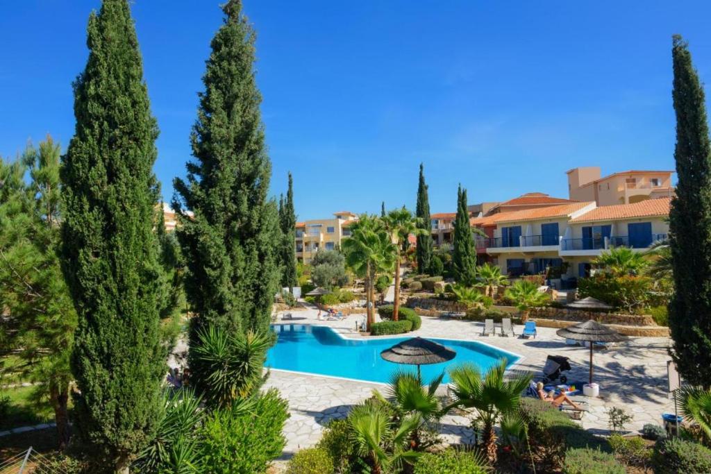 a view of a resort with a pool and trees at 1 bedroom in Regina Gardes 2 in Paphos City