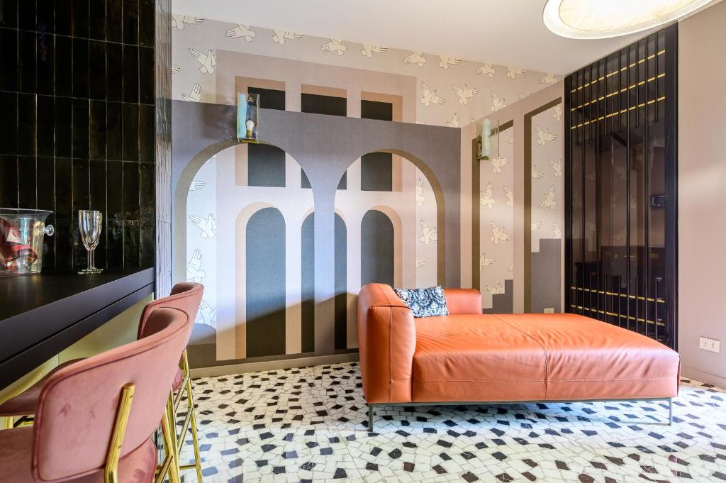 ein orangefarbenes Sofa in einem Zimmer mit Tisch und Stühlen in der Unterkunft Boutique suite Rome in Rom